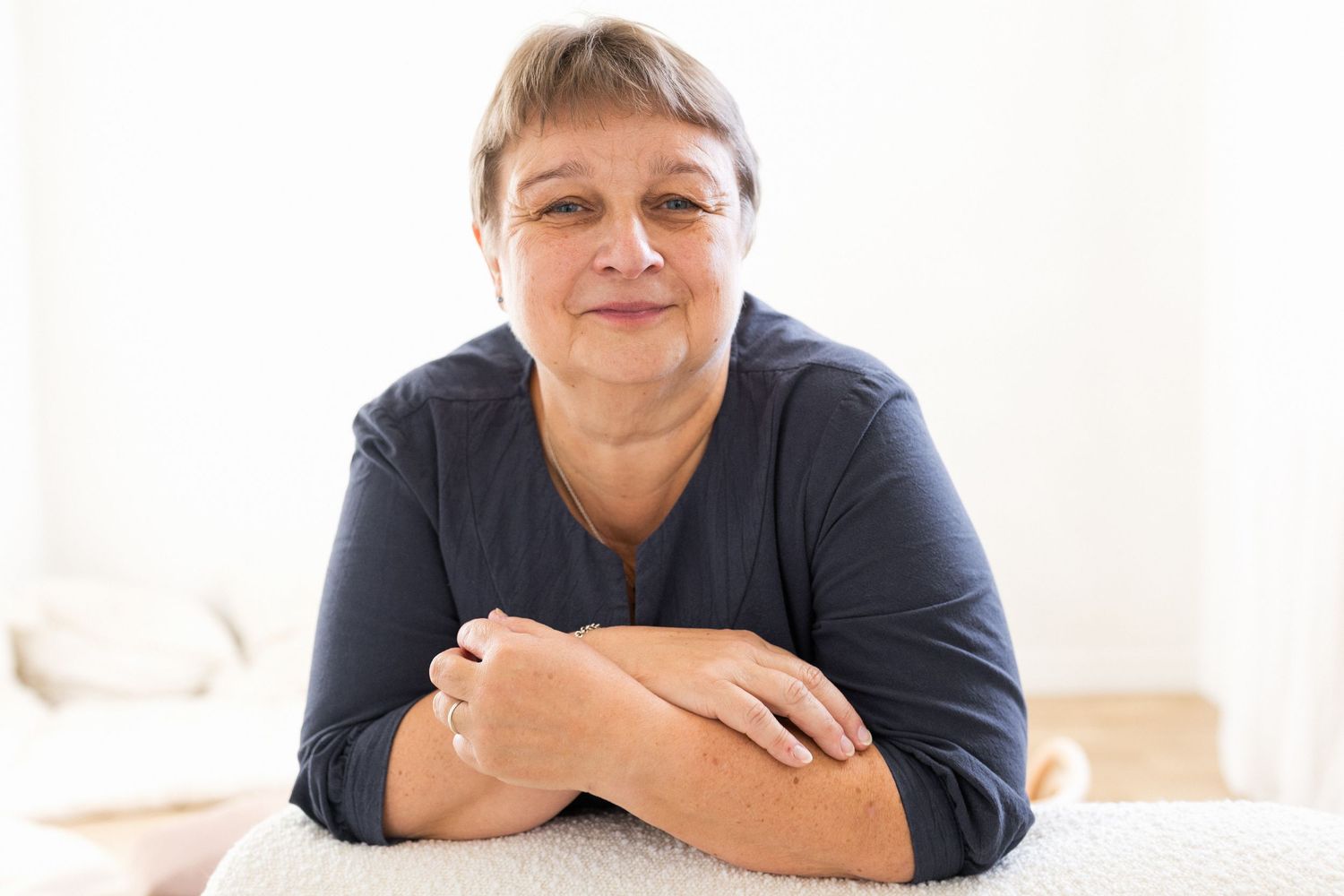 Nainen nojailee tuolin selkämykseen, muotokuvaus