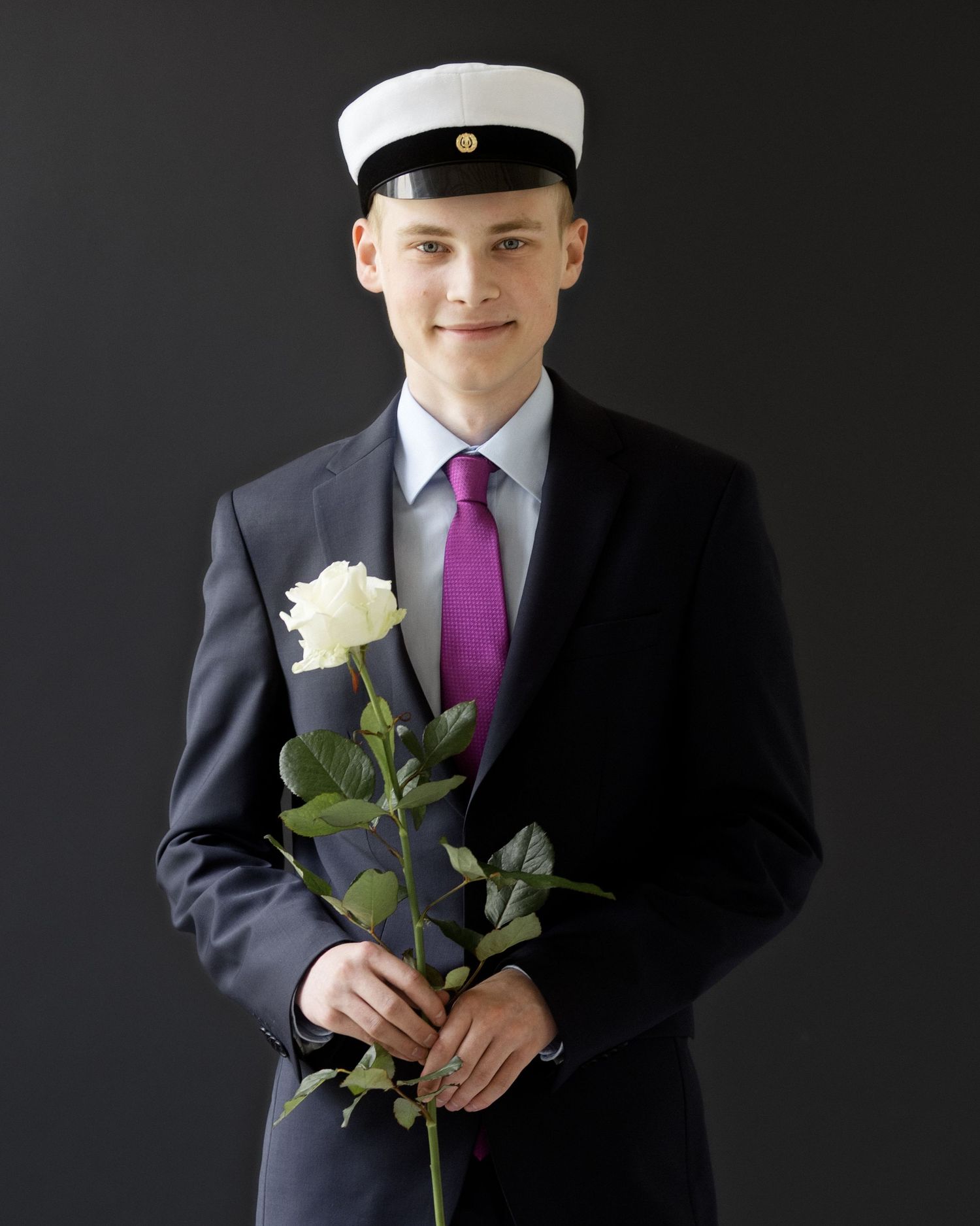 poika puvussa ruusu kädessä- Ylioppilaskuvaus Helsinki