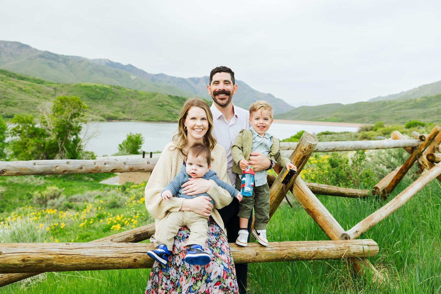 Family on fence at Little Dell Reservoir photography by Av Potter Photo a Utah wedding and lifestyle photographer