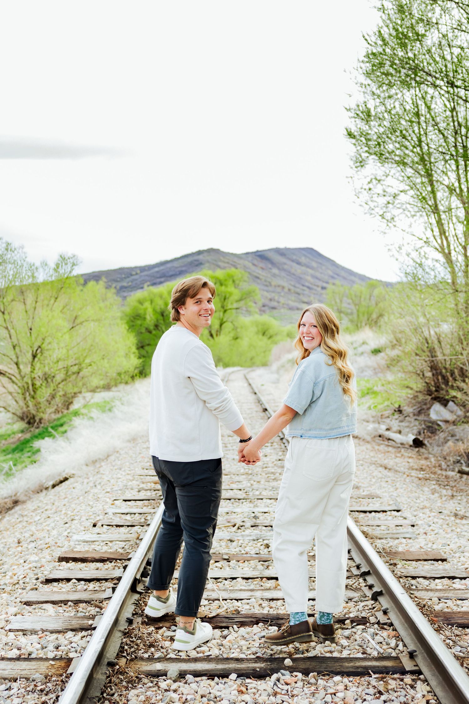 Couple on train tracks at Historic Tate Barn photography by Av Potter Photo a Utah wedding and lifestyle photographer