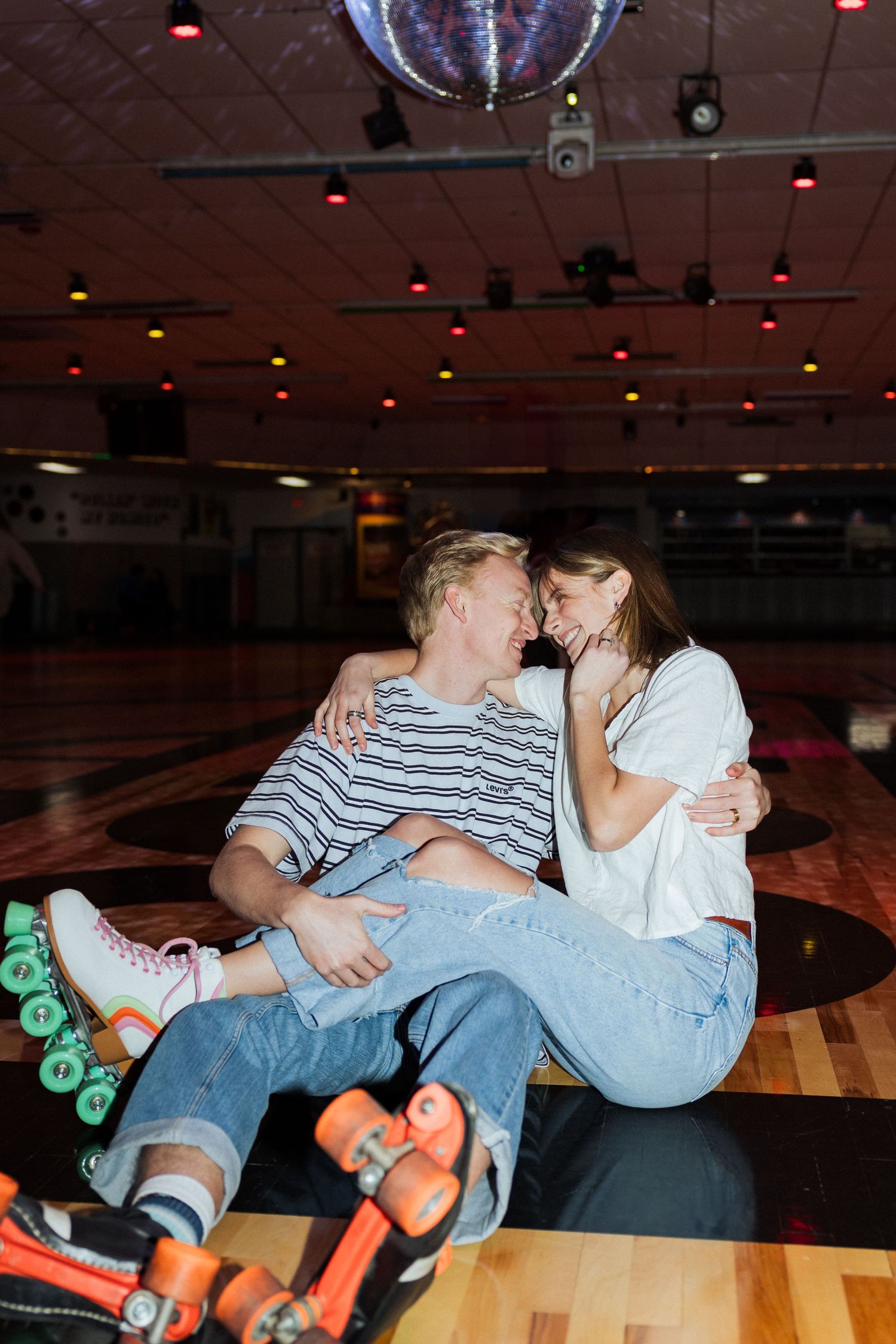 Couple under disco ball at Classic Skating in Orem photography by Av Potter Photo a Utah wedding and lifestyle photographer