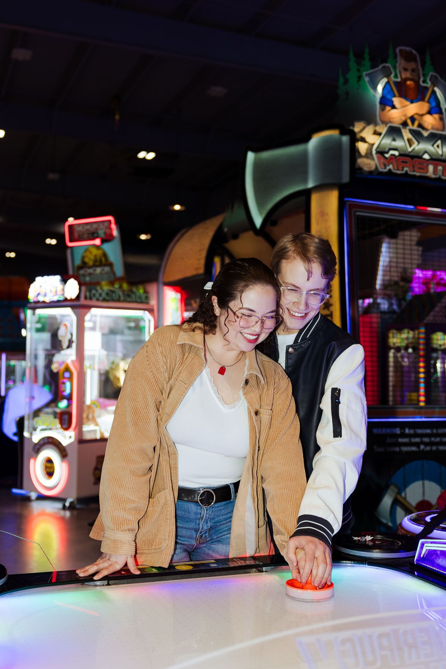 Couple playing air hockey at Classic Skating in Orem photography by Av Potter Photo a Utah wedding and lifestyle photographer
