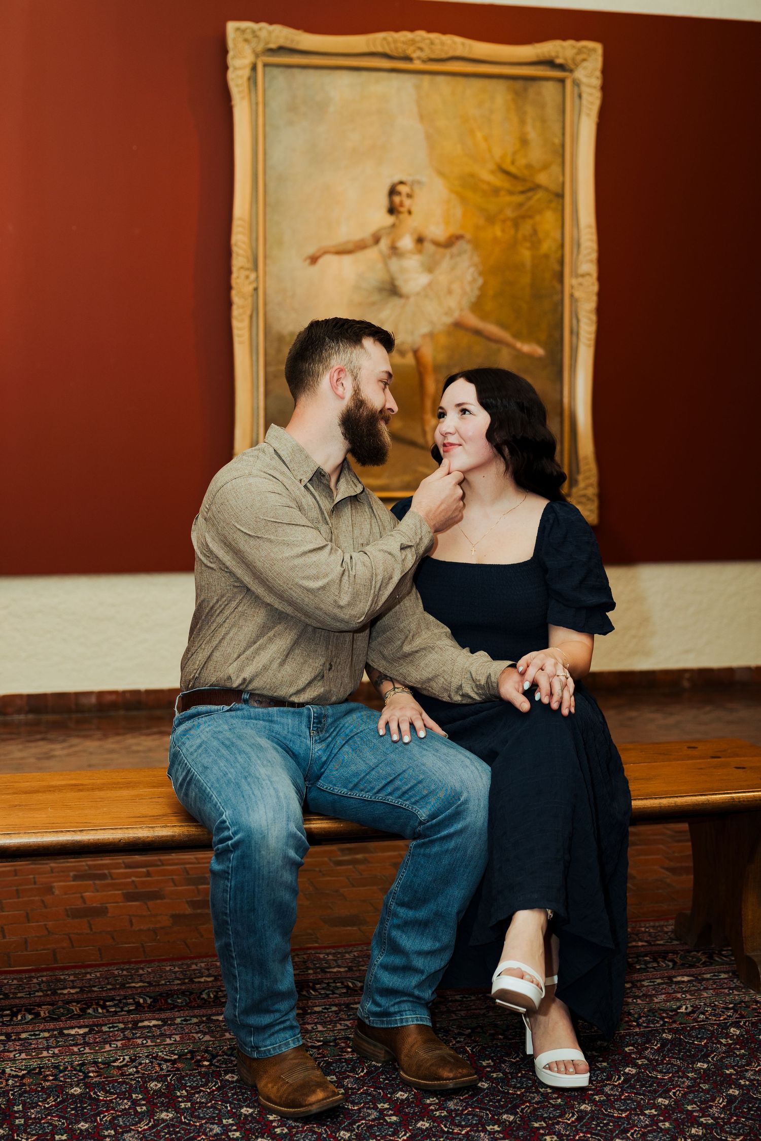 Couple sitting on bench at the Springville Art Museum photography by Av Potter Photo a Utah wedding and lifestyle photographer