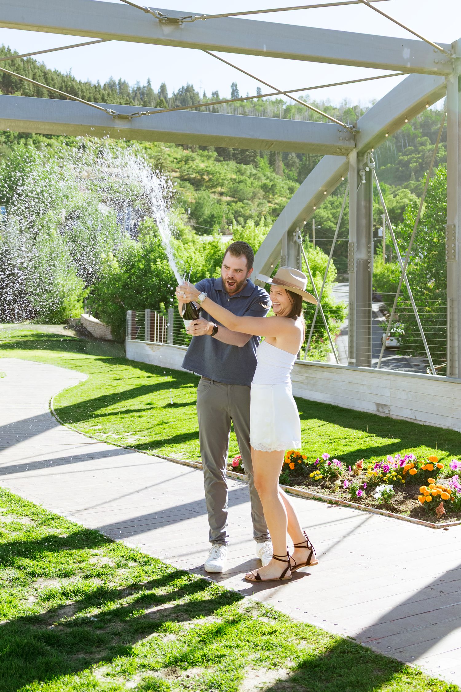 Couple popping champagne at Park City Main Street photography by Av Potter Photo a Utah wedding and lifestyle photographer