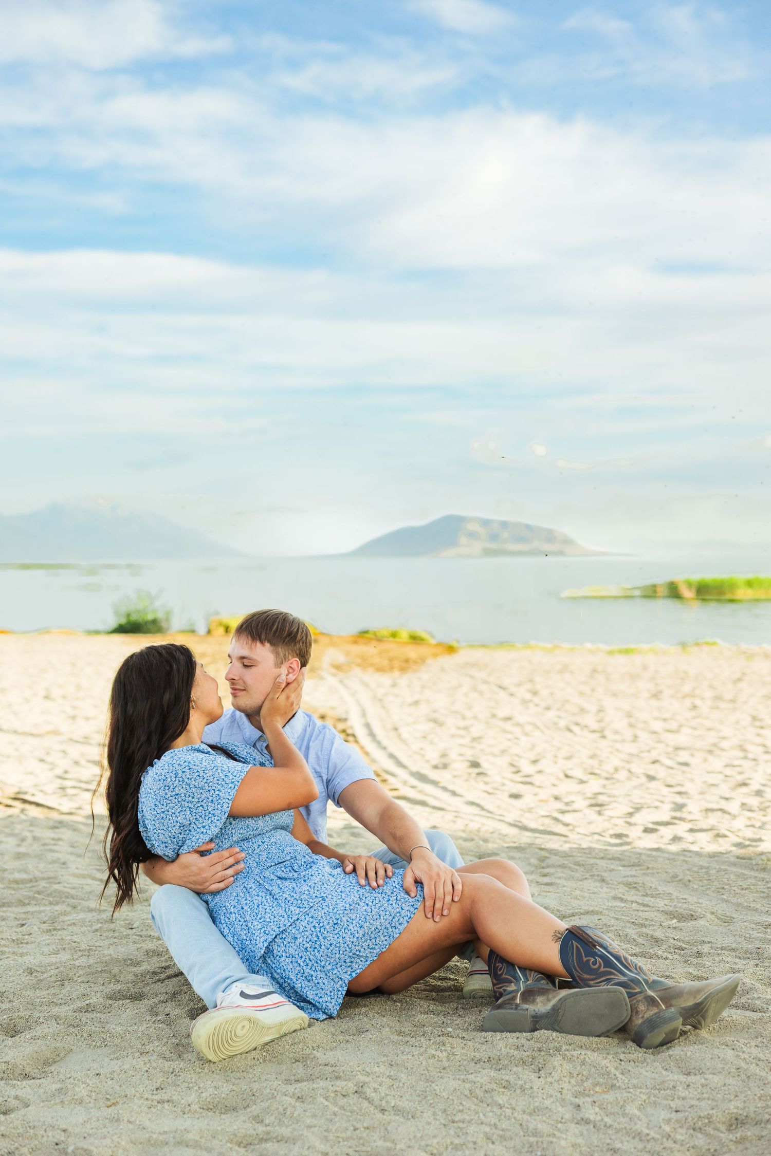 Couple sitting on sand at the Utah Lake photography by Av Potter Photo a Utah wedding and lifestyle photographer