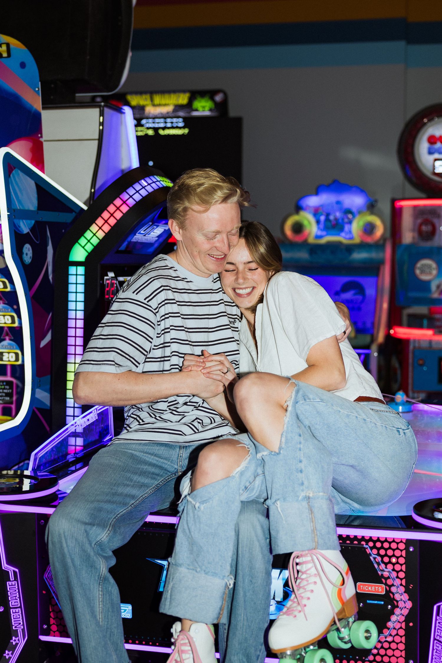 Couple on arcade game at Classic Skating in Orem photography by Av Potter Photo a Utah wedding and lifestyle photographer