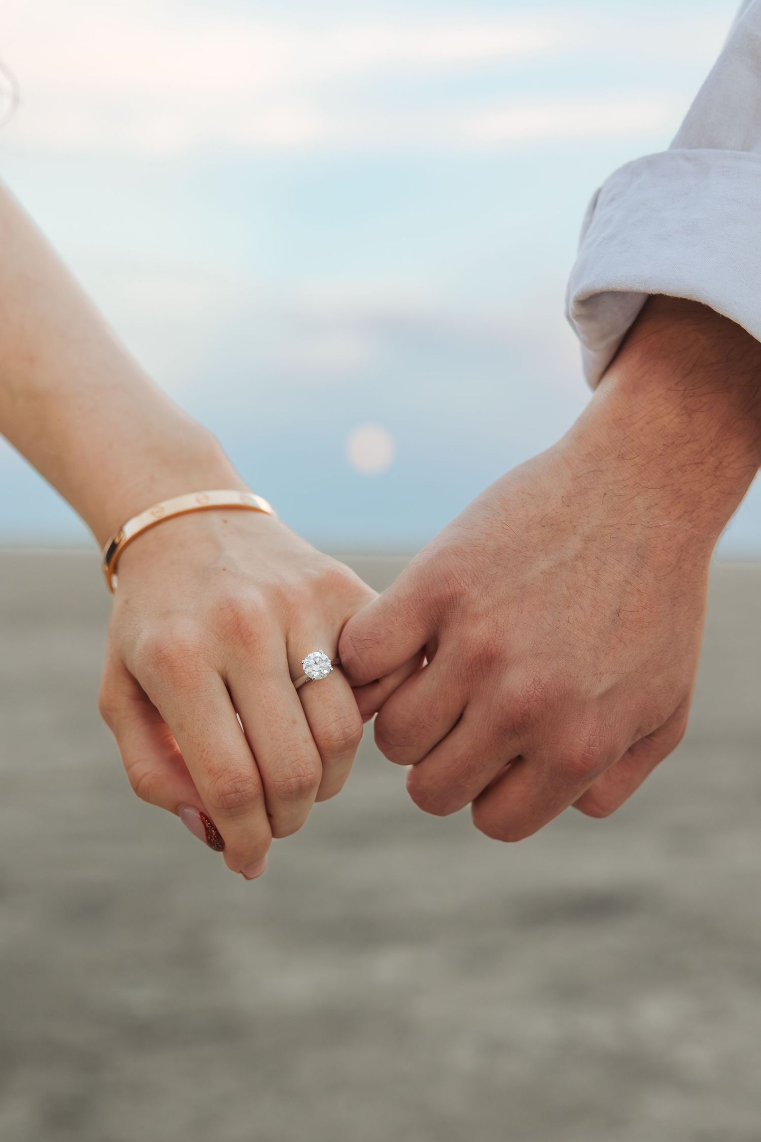 Couple holding pinkies at The Bonneville Salt Flats photography by Av Potter Photo a Utah wedding and lifestyle photographer