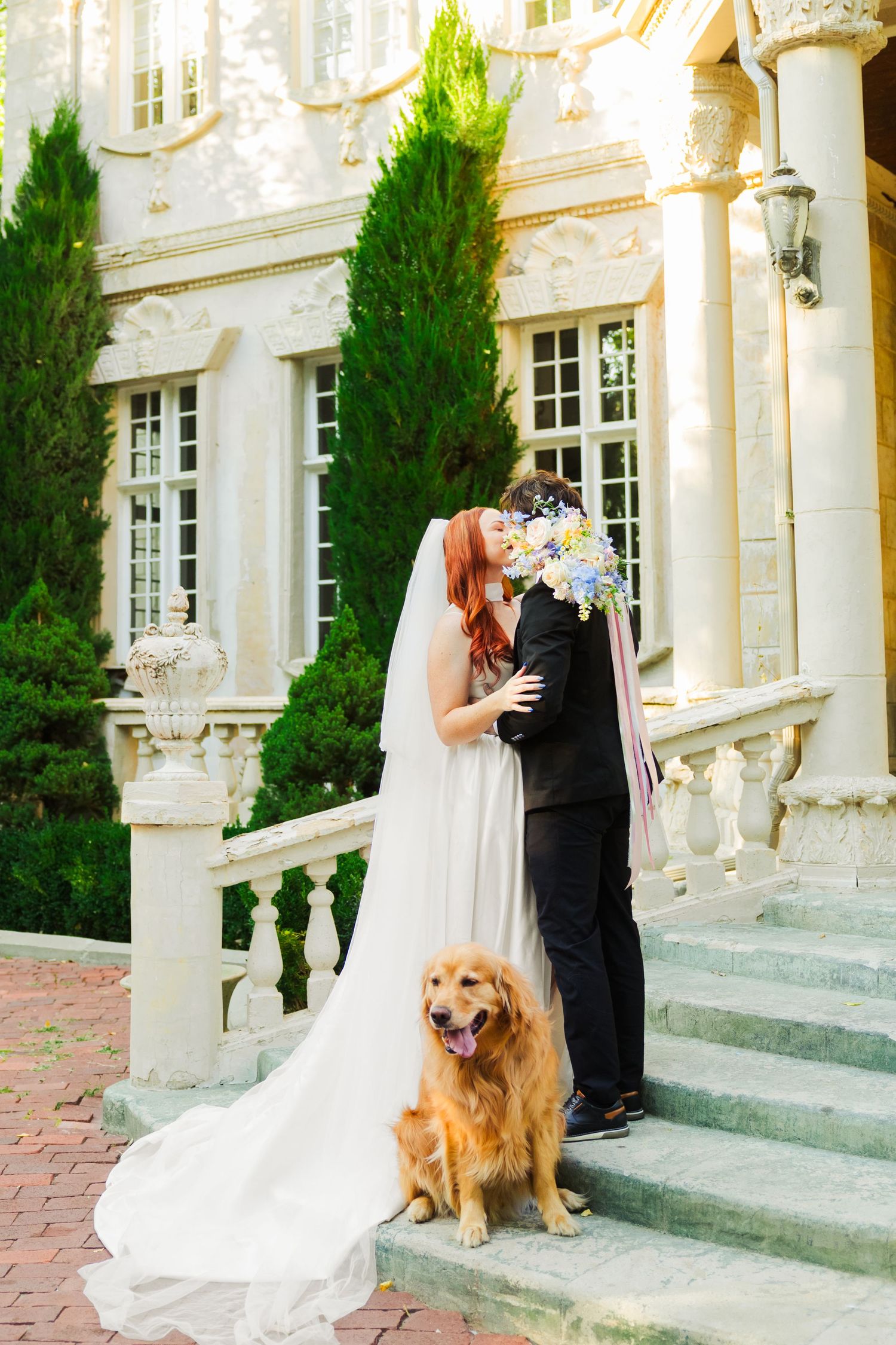 Bride and groom kissing with dog at La Caille photography by Av Potter Photo a Utah wedding and lifestyle photographer