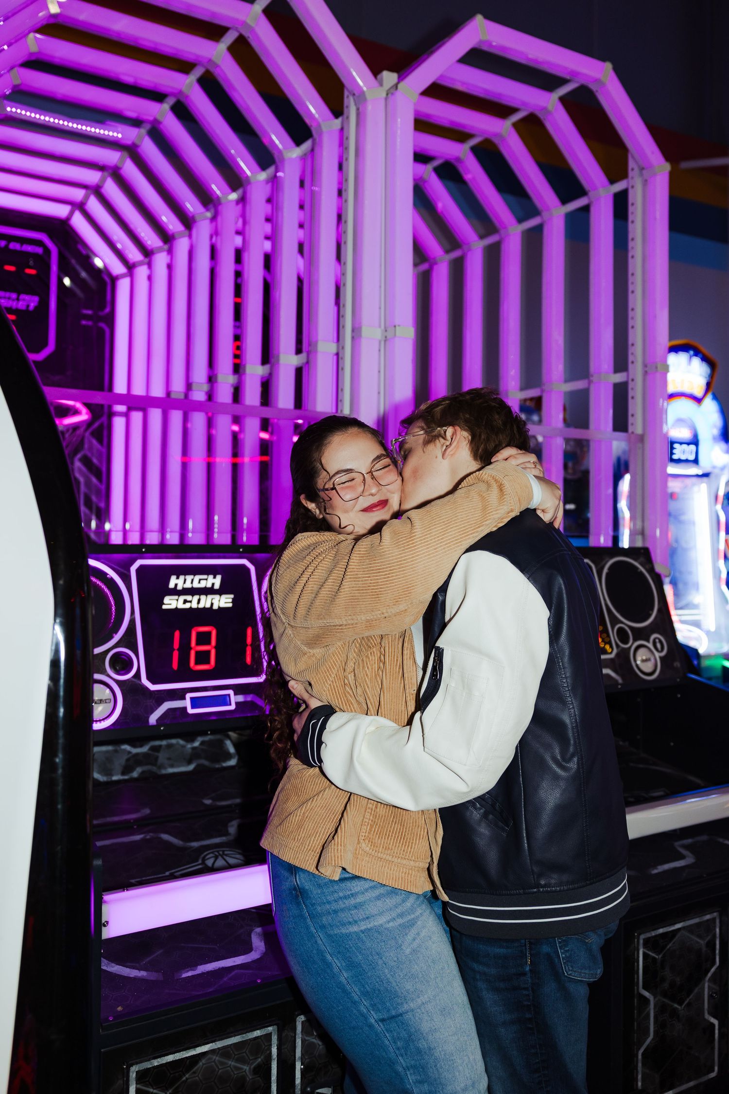 Couple sitting on arcade game at Classic Skating in Orem photography by Av Potter Photo a Utah wedding and lifestyle photographer
