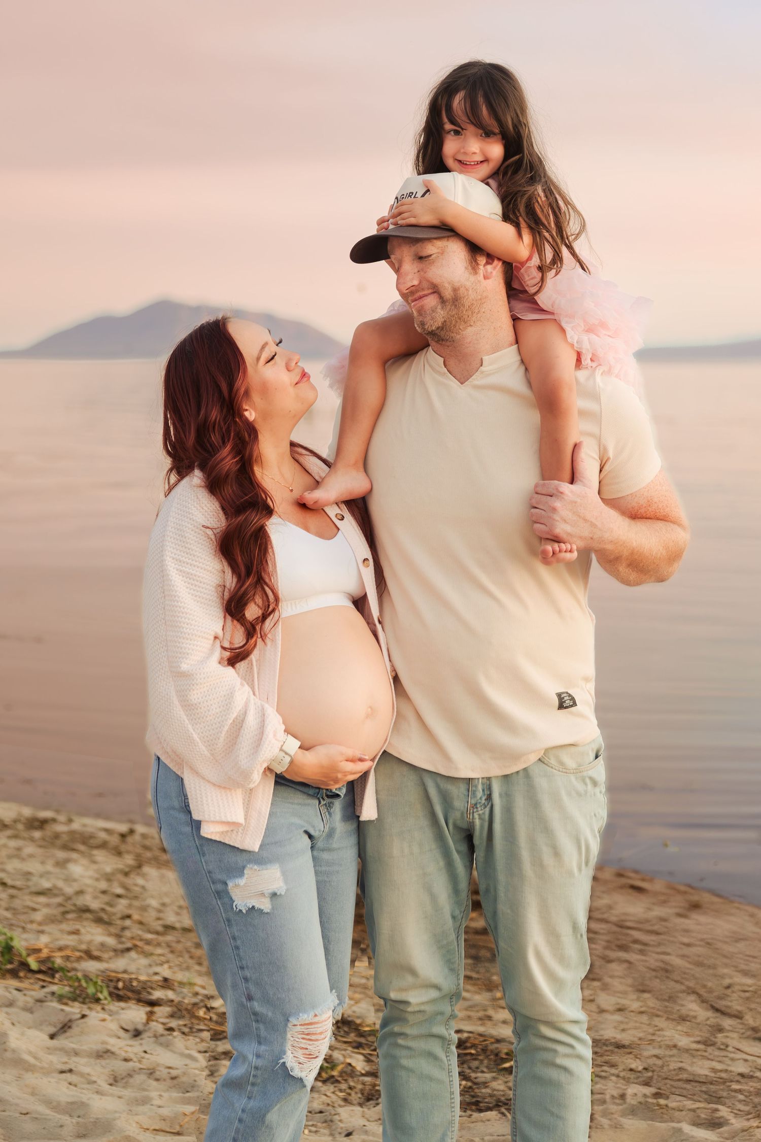 Pregnant woman with husband and daughter at the Utah Lake photography by Av Potter Photo a Utah wedding and lifestyle photographer