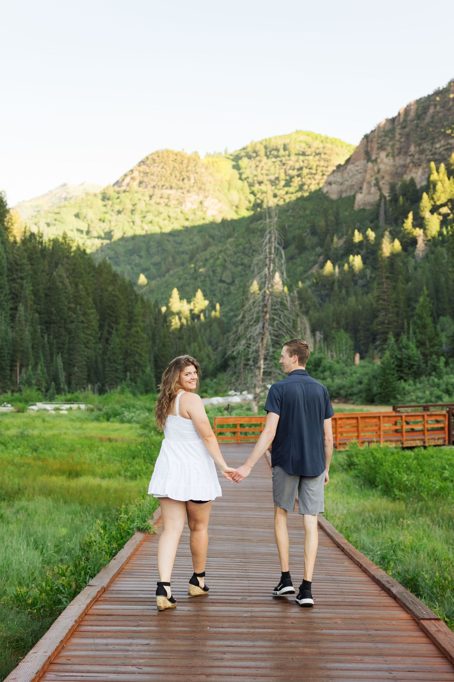 Couple walking on board walk at Jordan Pines Campground photography by Av Potter Photo a Utah wedding and lifestyle photographer
