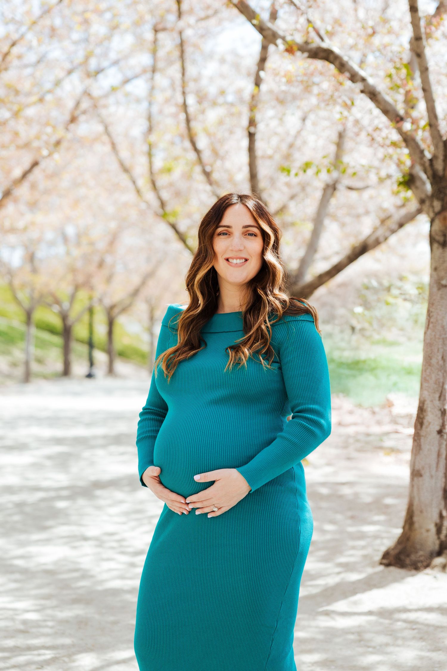 Pregnant woman during cherry blossoms at The Utah State Capitol photography by Av Potter Photo a Utah wedding and lifestyle photographer