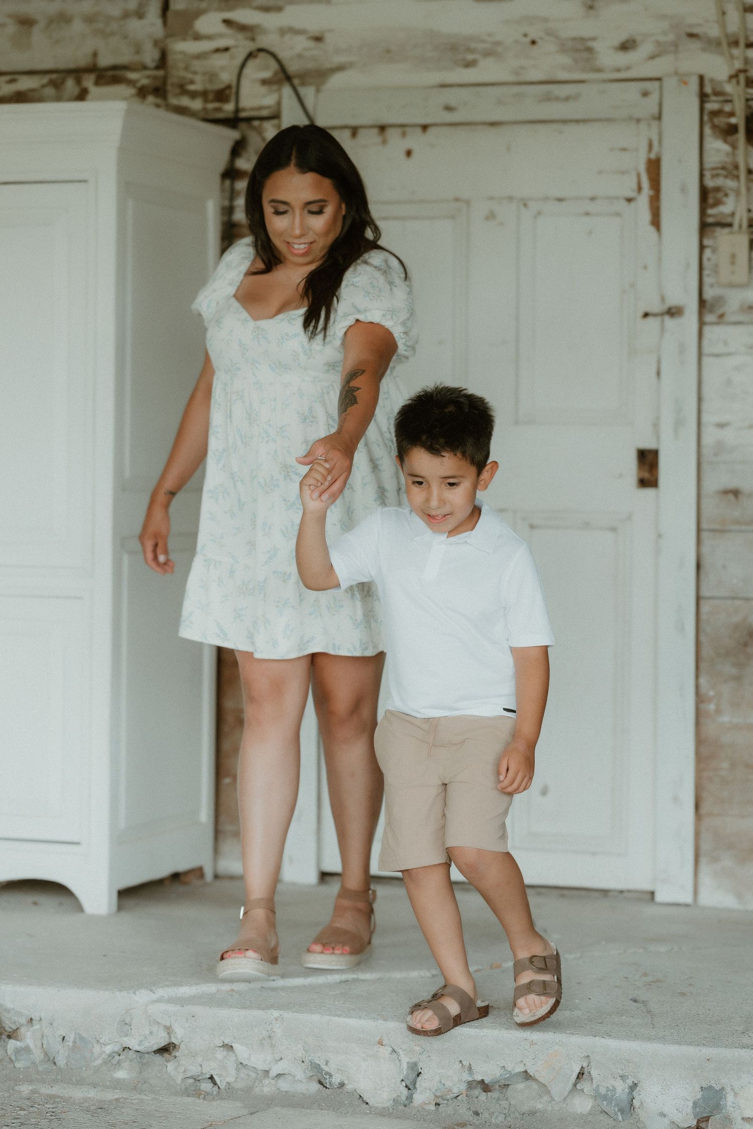 Casual portraits on a white porch with rustic detailing and neutral tones.