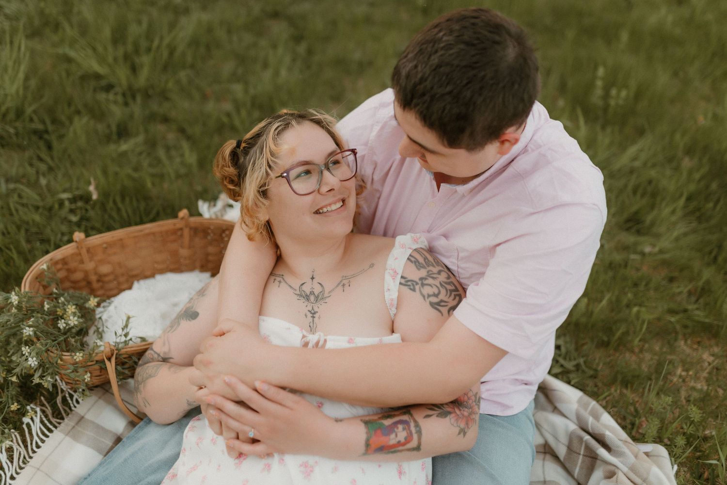 An intimate outdoor portrait session in a grassy field with soft natural lighting.