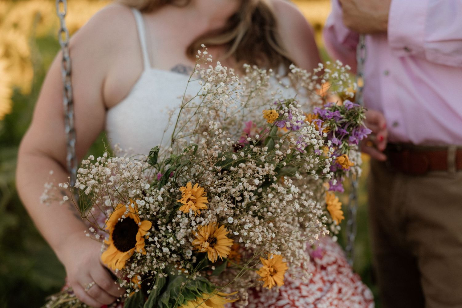 Close-up of a rustic wildflower bouquet featuring sunflowers and baby's breath.