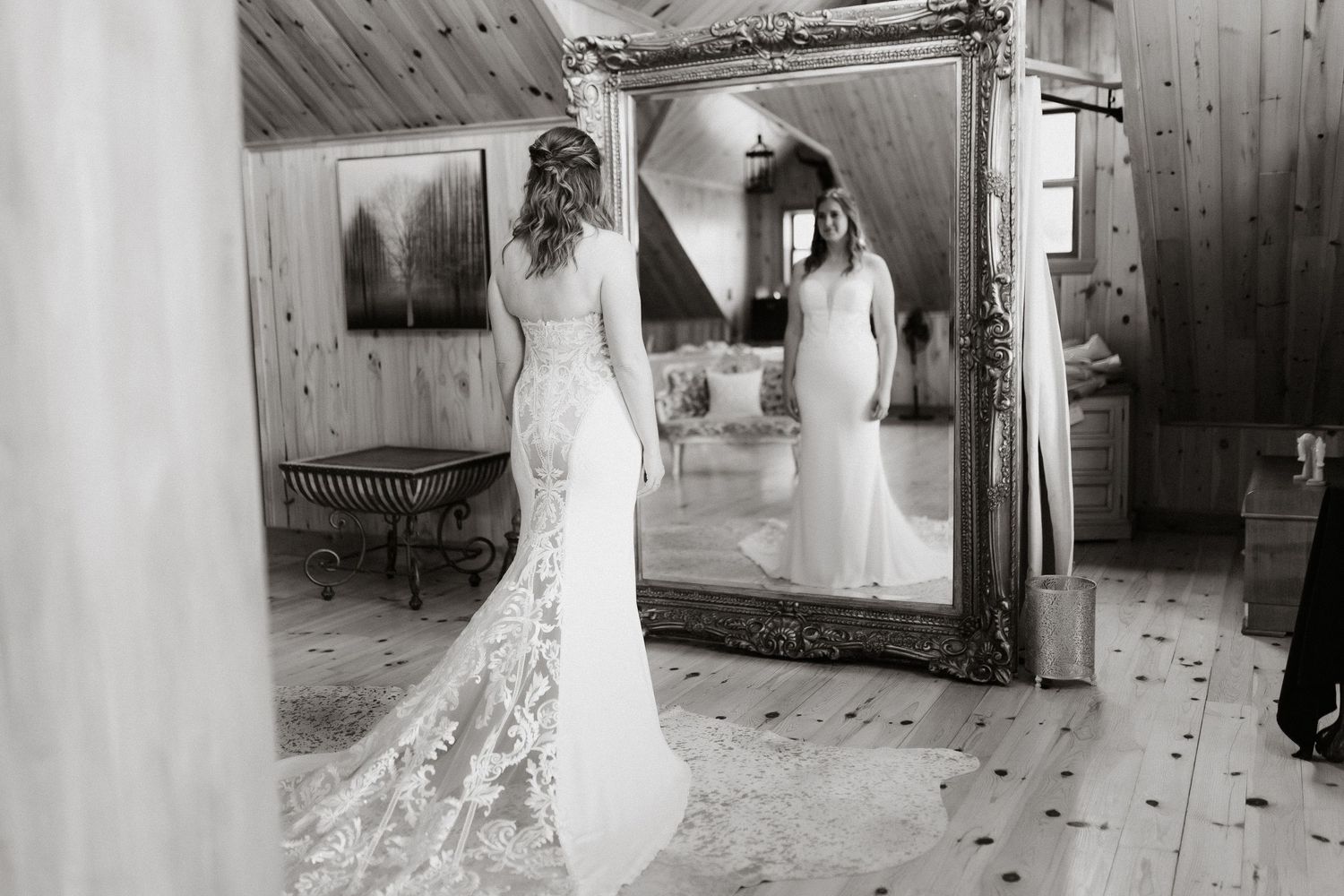 A wedding dress silhouette reflected in a rustic wooden room mirror.