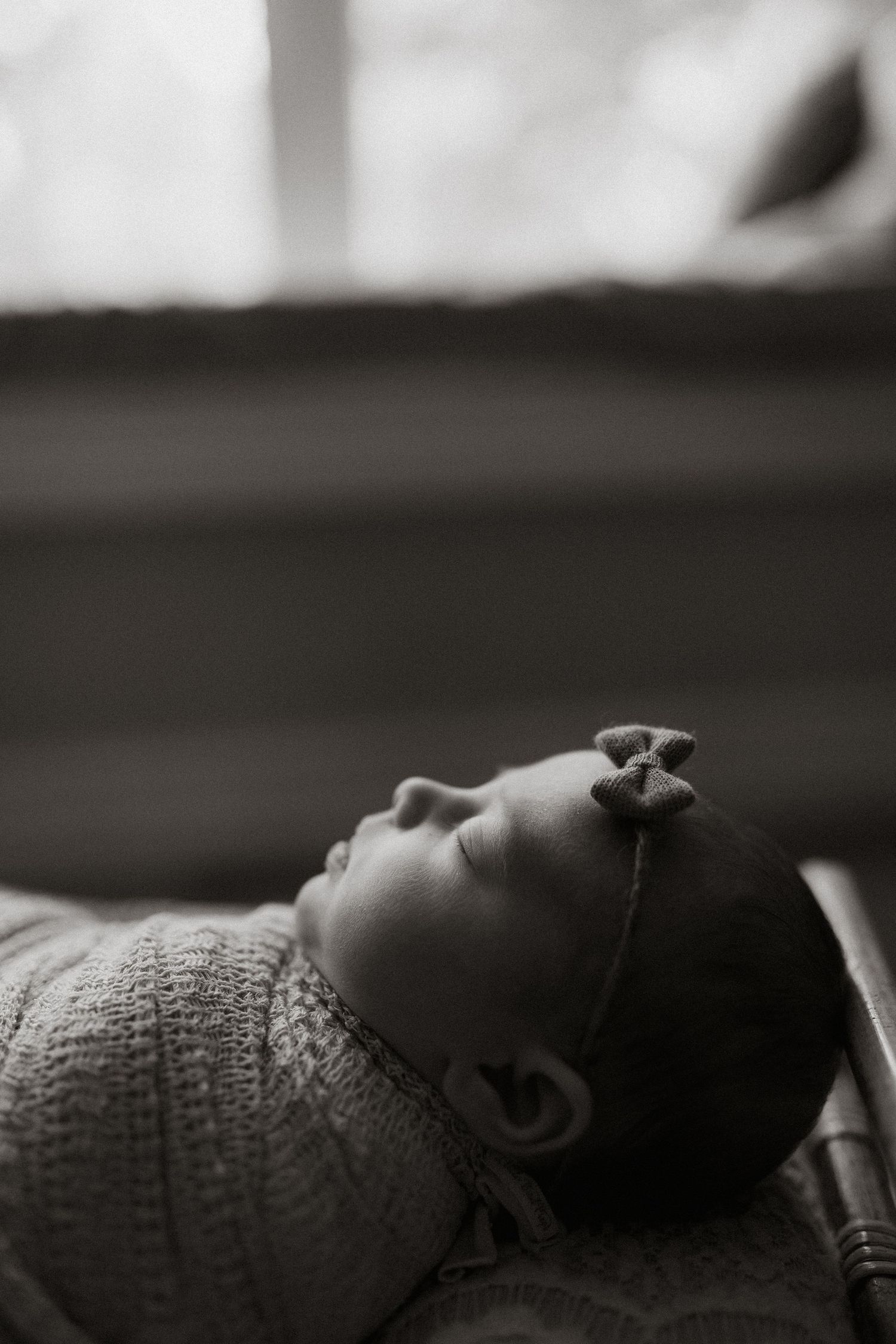 Black and white close-up portraits of a sleeping infant with textured blanket details.