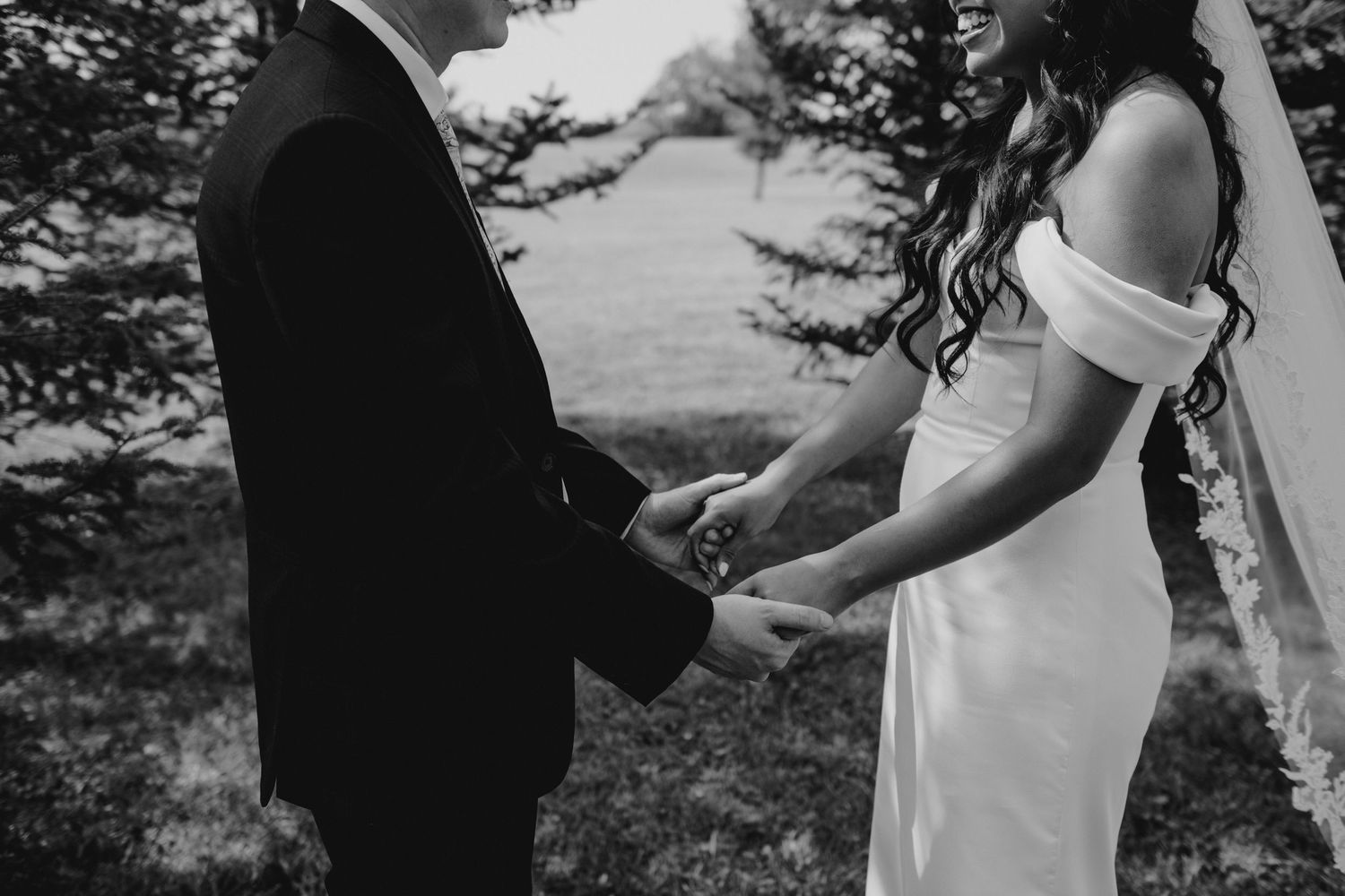 A couple shares an intimate moment during their wedding ceremony in a black and white photograph.