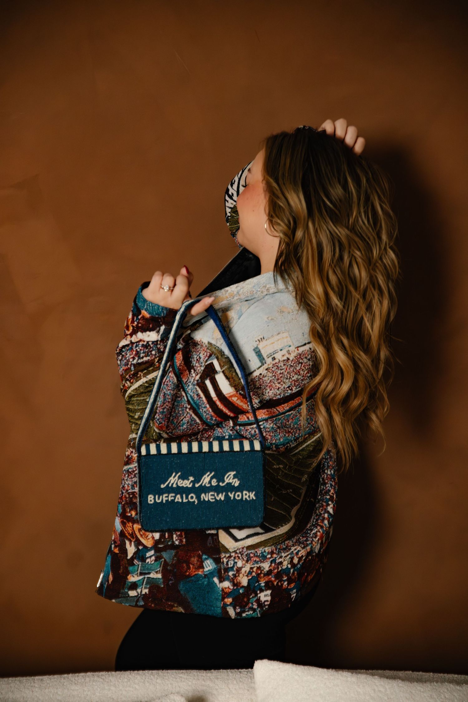 A series of four artistic photographs showing someone reading a blue book against a dark brown background.