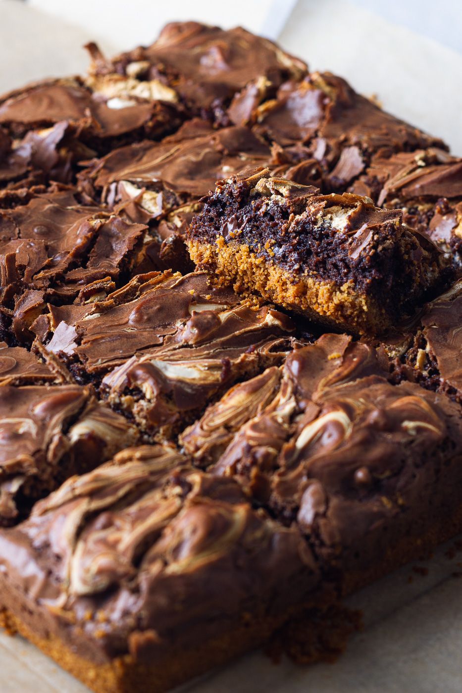 Rich chocolate brownie squares with fudgy layers and swirled chocolate topping cut to show gooey interior texture.
