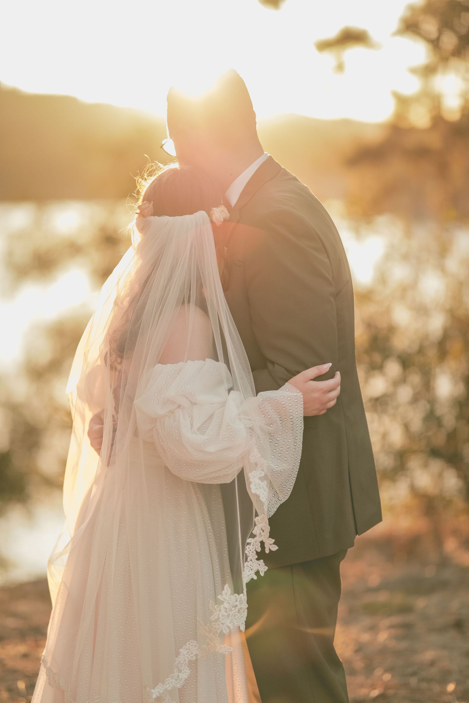 couple embracing by a lakeside in Big Bear Lake with golden hour, sunset tones