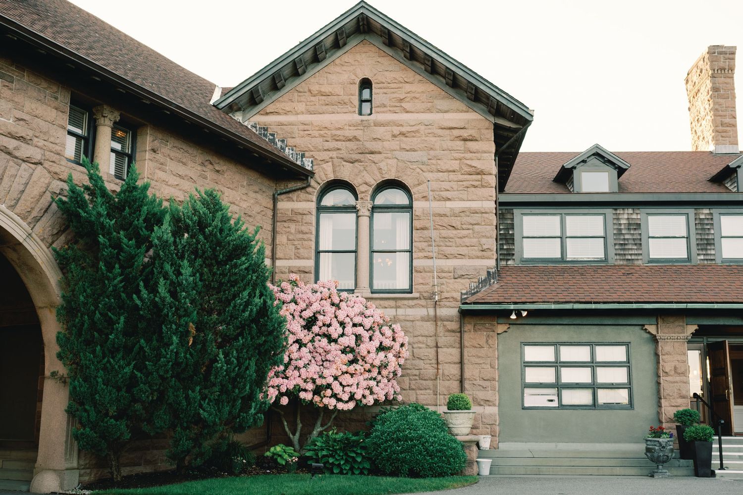 Contemporary tan stucco house with stone accents and a modern garage door design features multiple architectural levels.