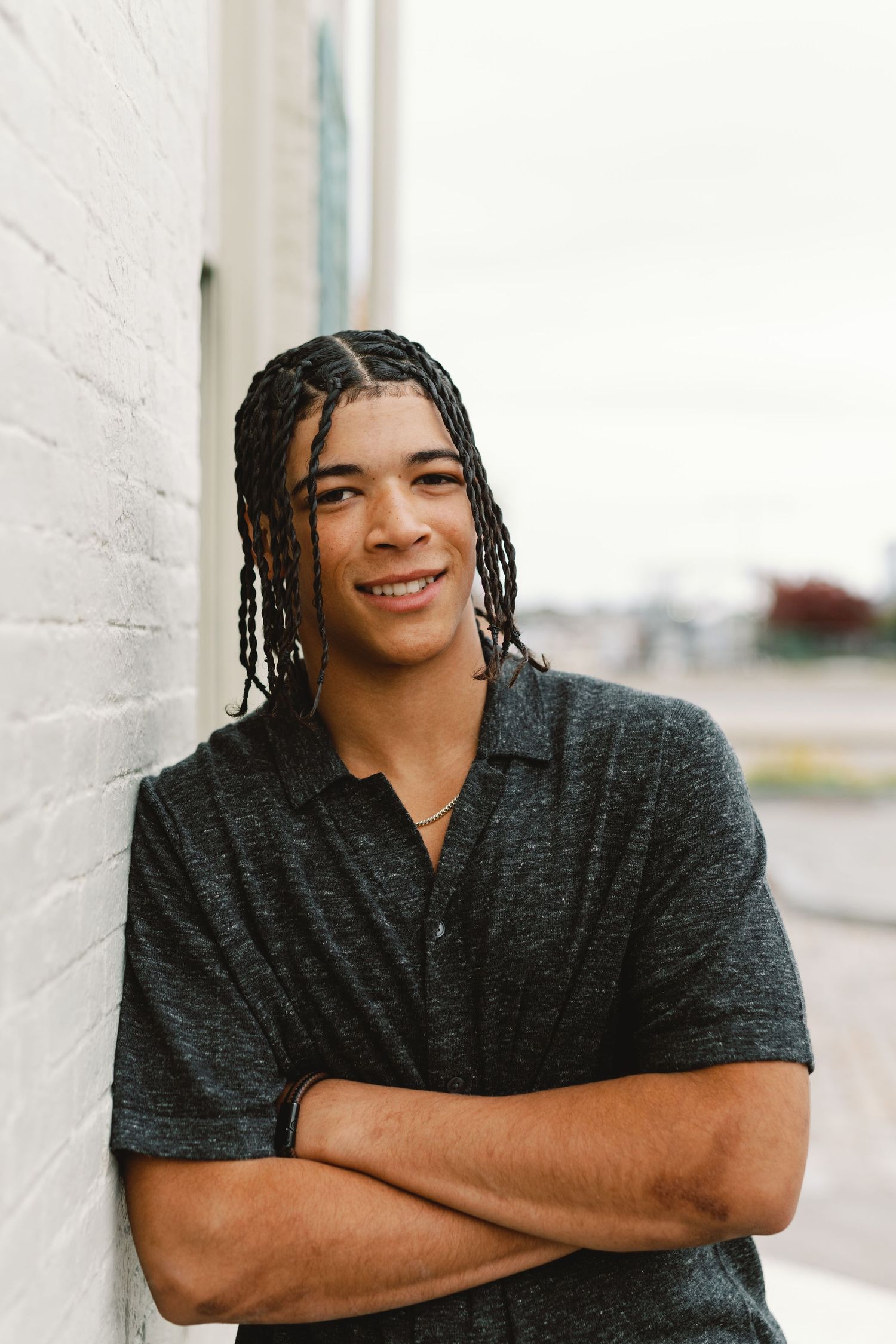 A series of portraits showing a person with dreadlocks wearing a dark shirt smiling against a light background.