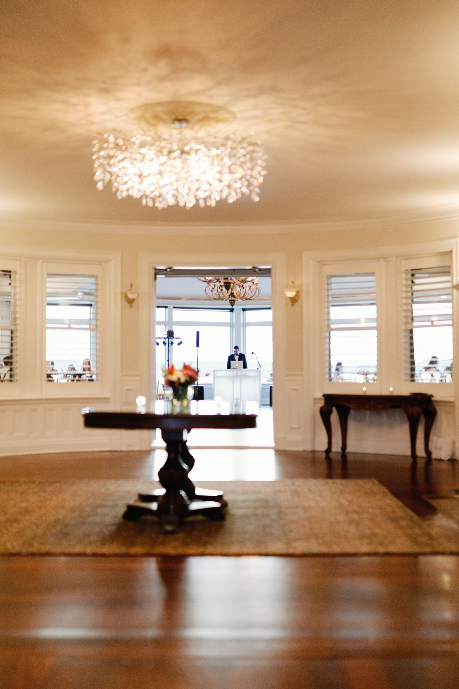 A panoramic sequence showing an elegant white dance studio space with hardwood floors and crystal chandeliers.