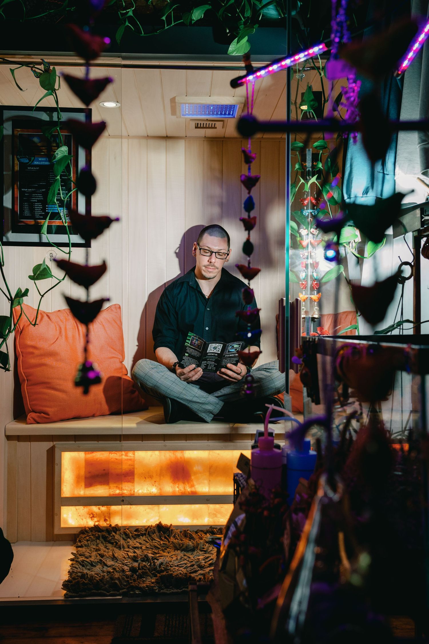 A dimly lit room with orange lighting and hanging decorative elements creates a moody atmosphere.