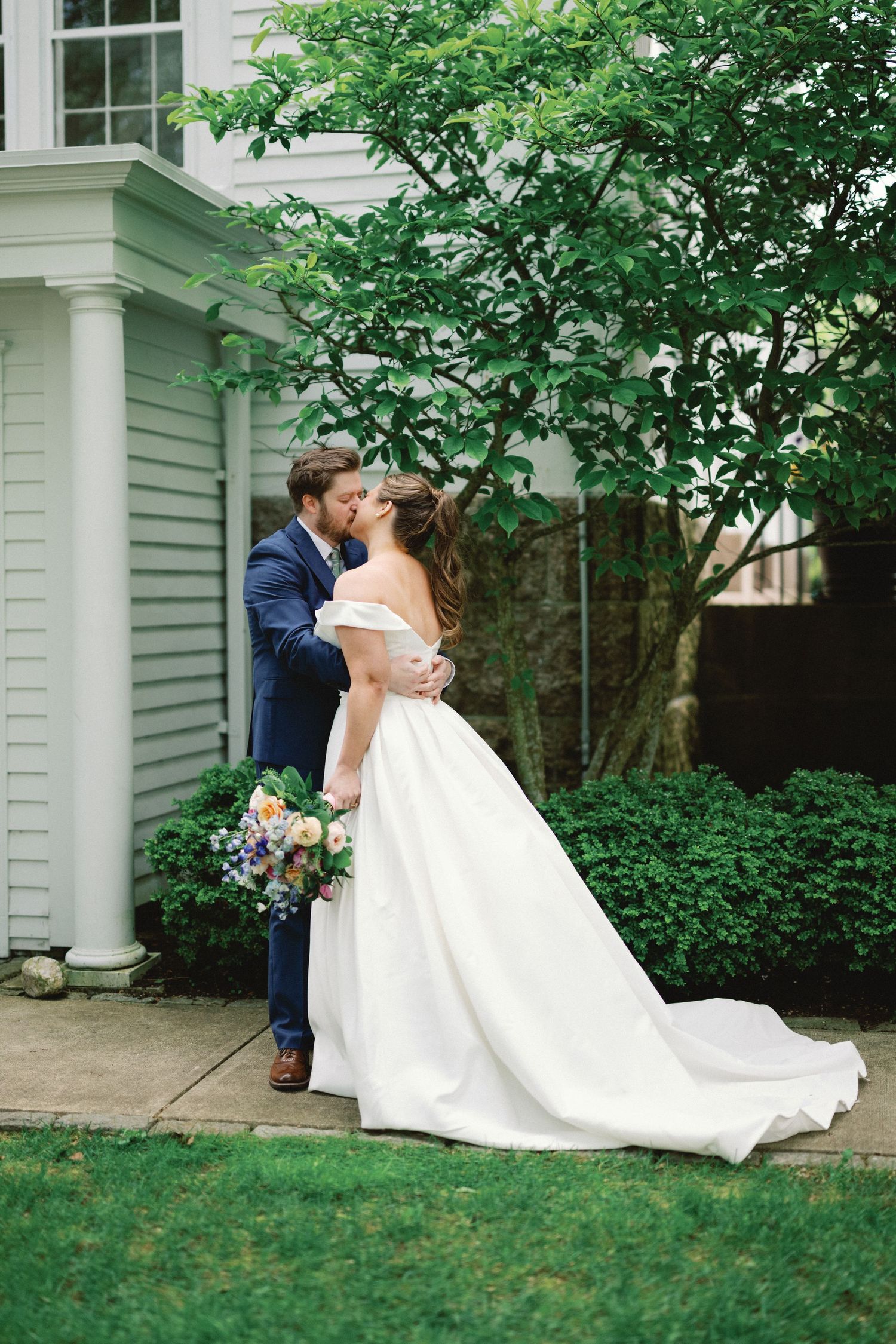 A romantic wedding couple shares kisses in garden setting captured in four sequential photos.