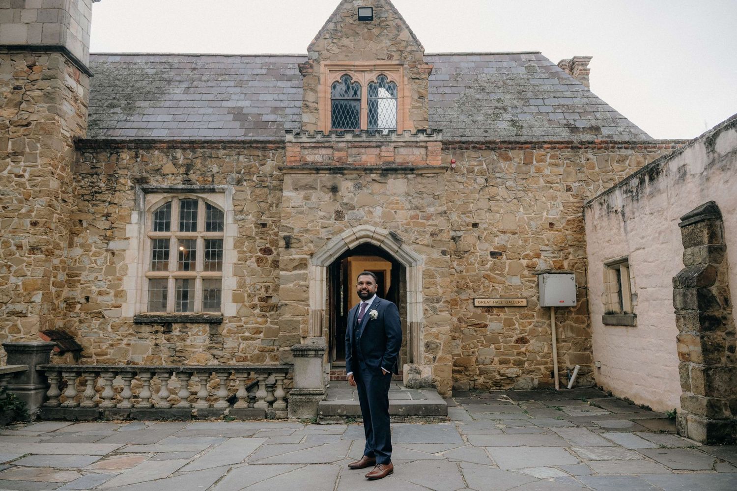 A sequential view of someone walking through a medieval stone archway and courtyard in winter.