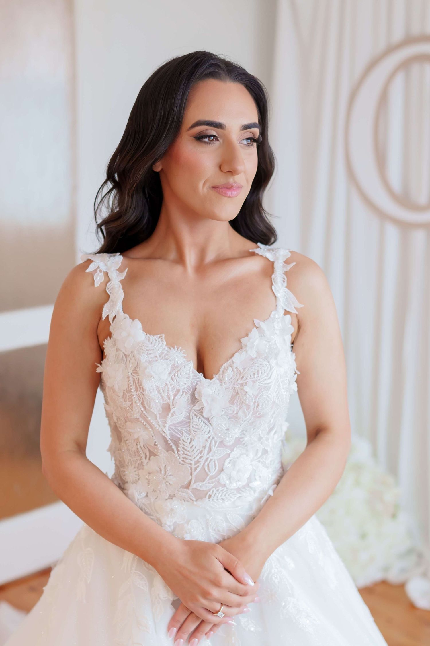 Elegant white lace wedding dress with delicate straps and sweetheart neckline in soft natural lighting.