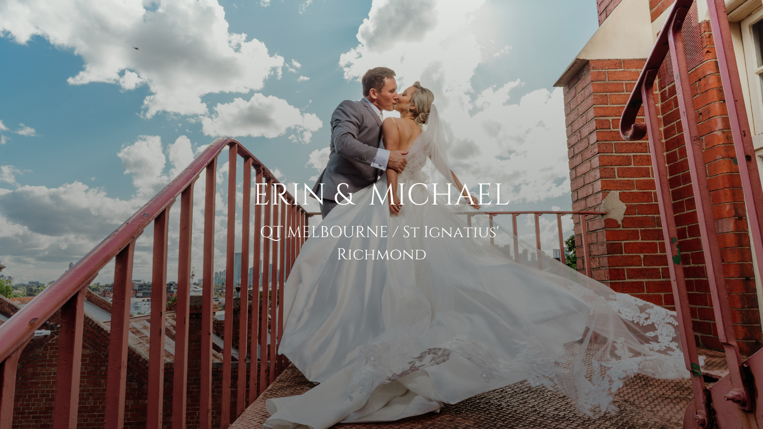 A romantic couple shares a tender moment on a rustic brick staircase with dramatic cloudy skies in the background.