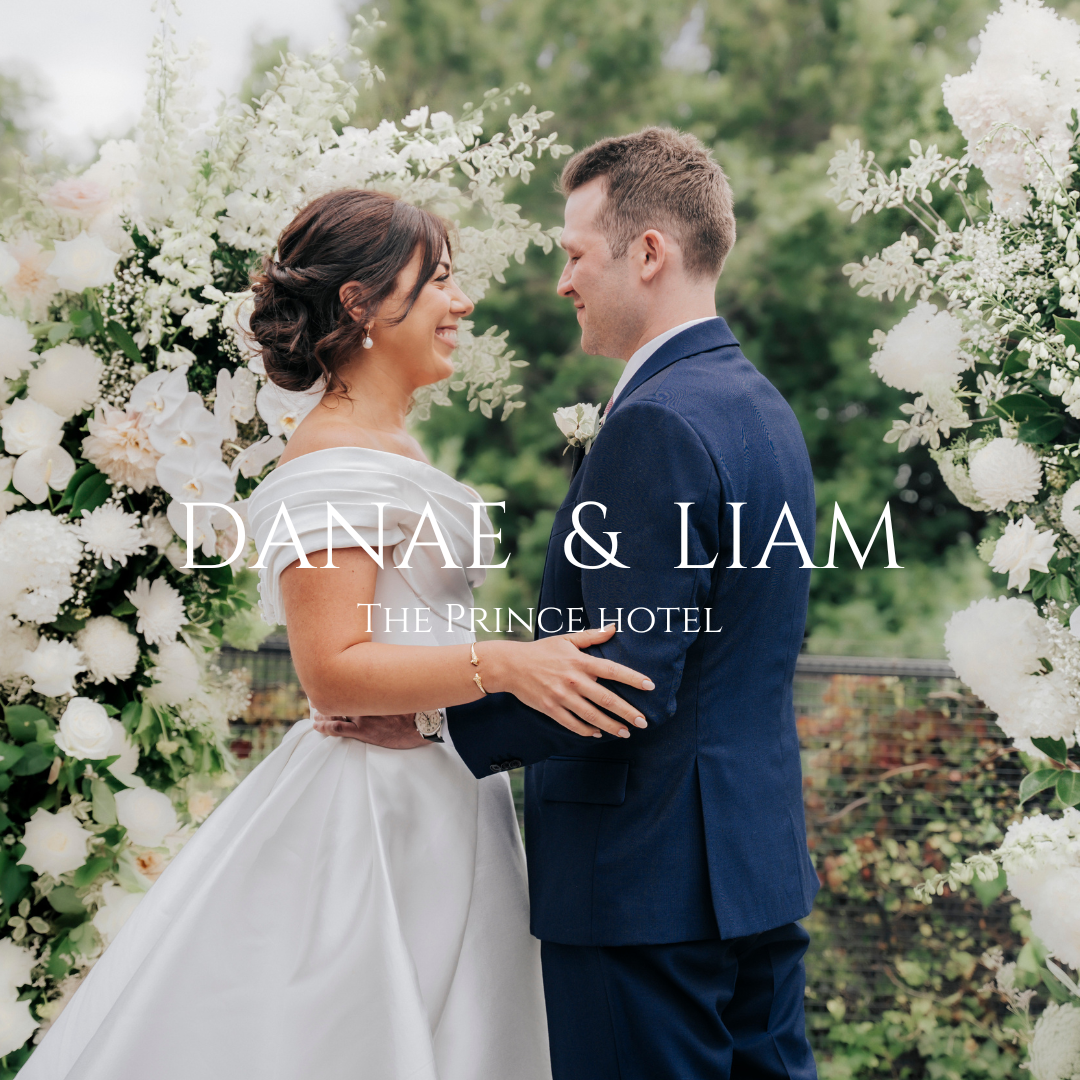 Romantic garden wedding portrait framed by white floral arch at Prince Hotel.