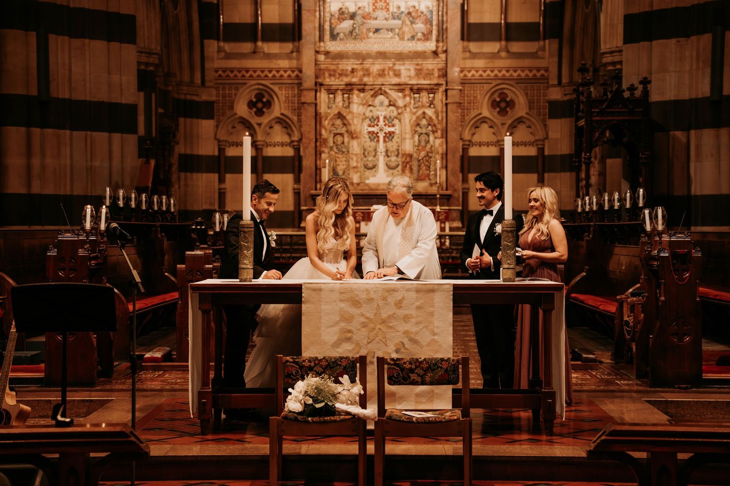A theatrical stage performance scene shows actors in period costumes interacting in a warmly lit interior setting.