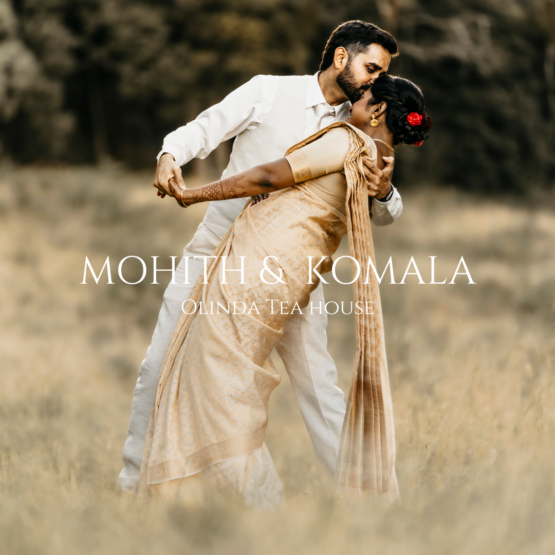 Romantic couple in traditional attire dancing in golden field at sunset.