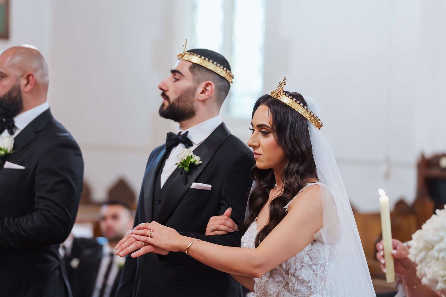 A joyful wedding celebration shows the bride and groom sharing vows during an elegant indoor ceremony.
