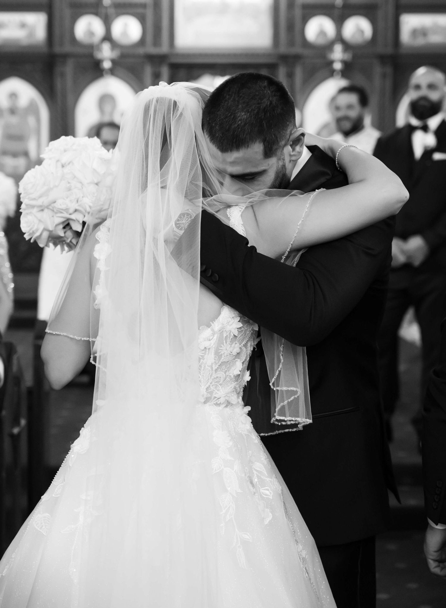 A beautiful wedding moment captured in black and white at a traditional church venue.