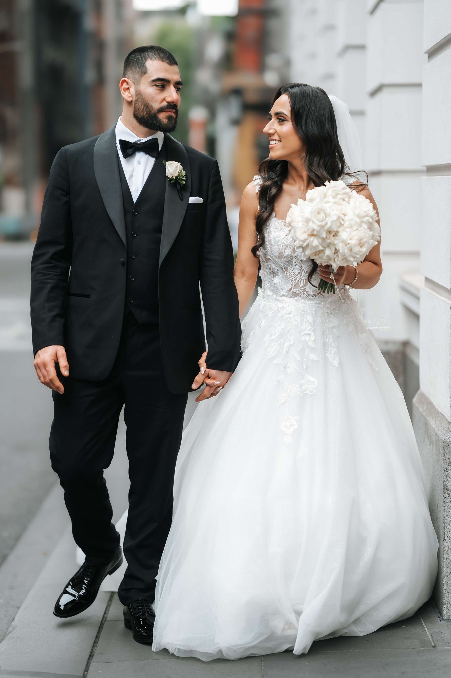 A bride and groom share joyful moments together in a series of romantic black and white wedding photos outdoors.