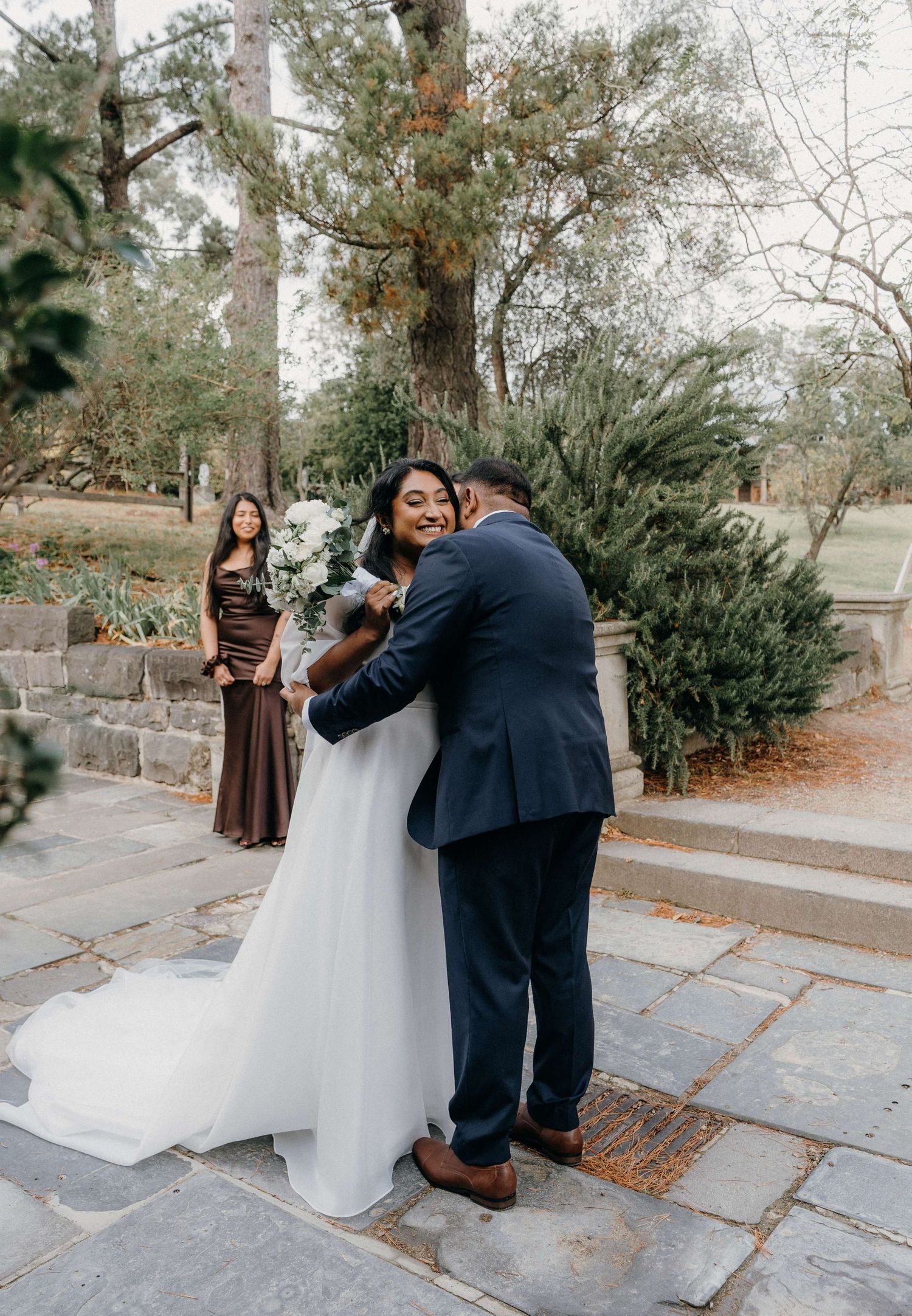 A romantic series of wedding photos showing a couple in formalwear sharing a tender moment on stone steps surrounded by trees.