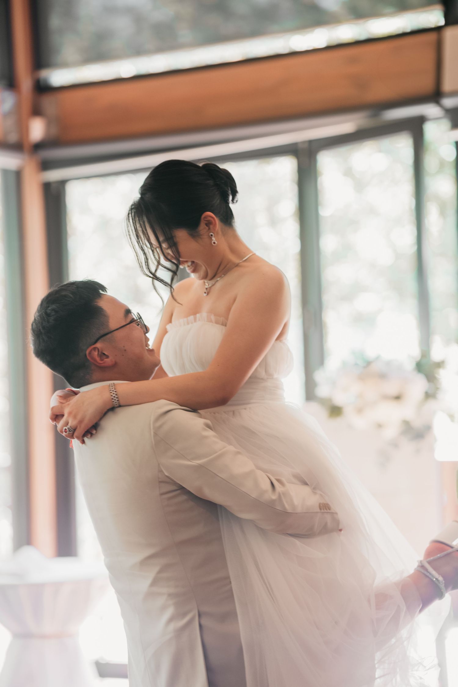 A couple share an intimate moment during their wedding dance, with the bride wearing a flowing white dress.