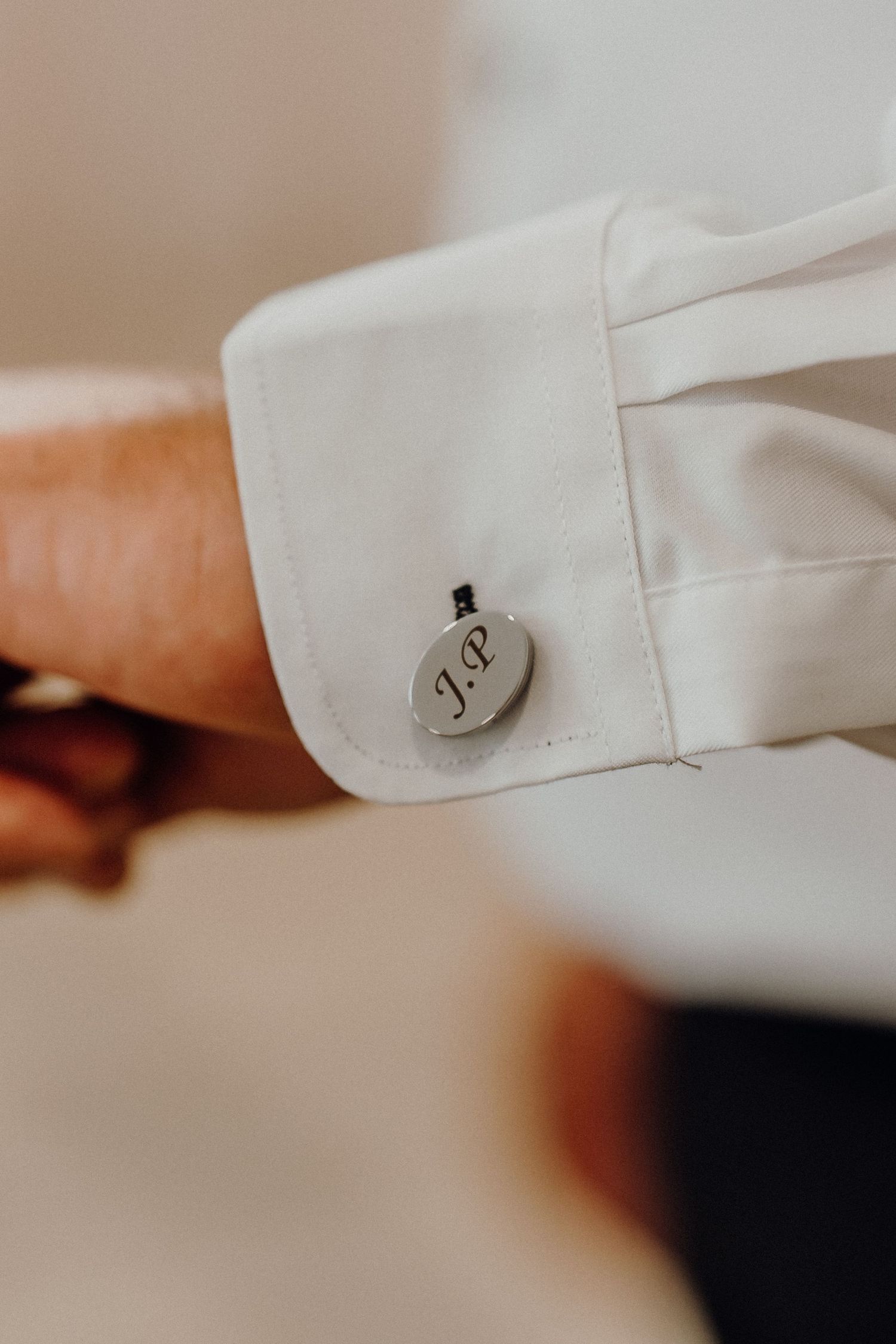 Close-up view of white shirt sleeve cuffs with decorative buttons in a row.