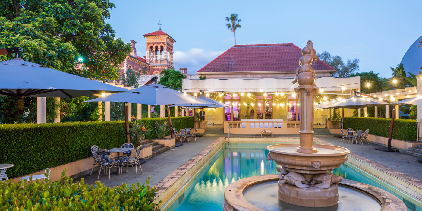 Luxury resort swimming pool with illuminated gazebo and outdoor seating area at dusk creates a tranquil atmosphere.
