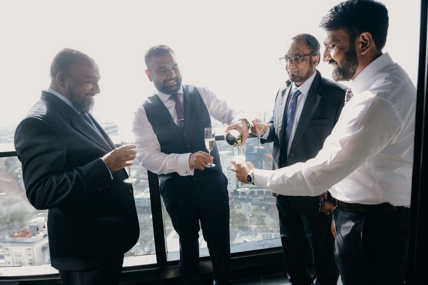 Business professionals gather in a bright meeting room with city views to discuss strategy and plans.