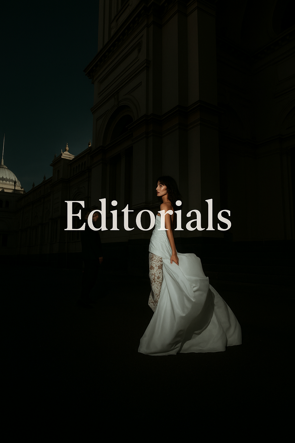 A dark moody editorial shot of a bride in a flowing white gown walking through shadows of a grand building.