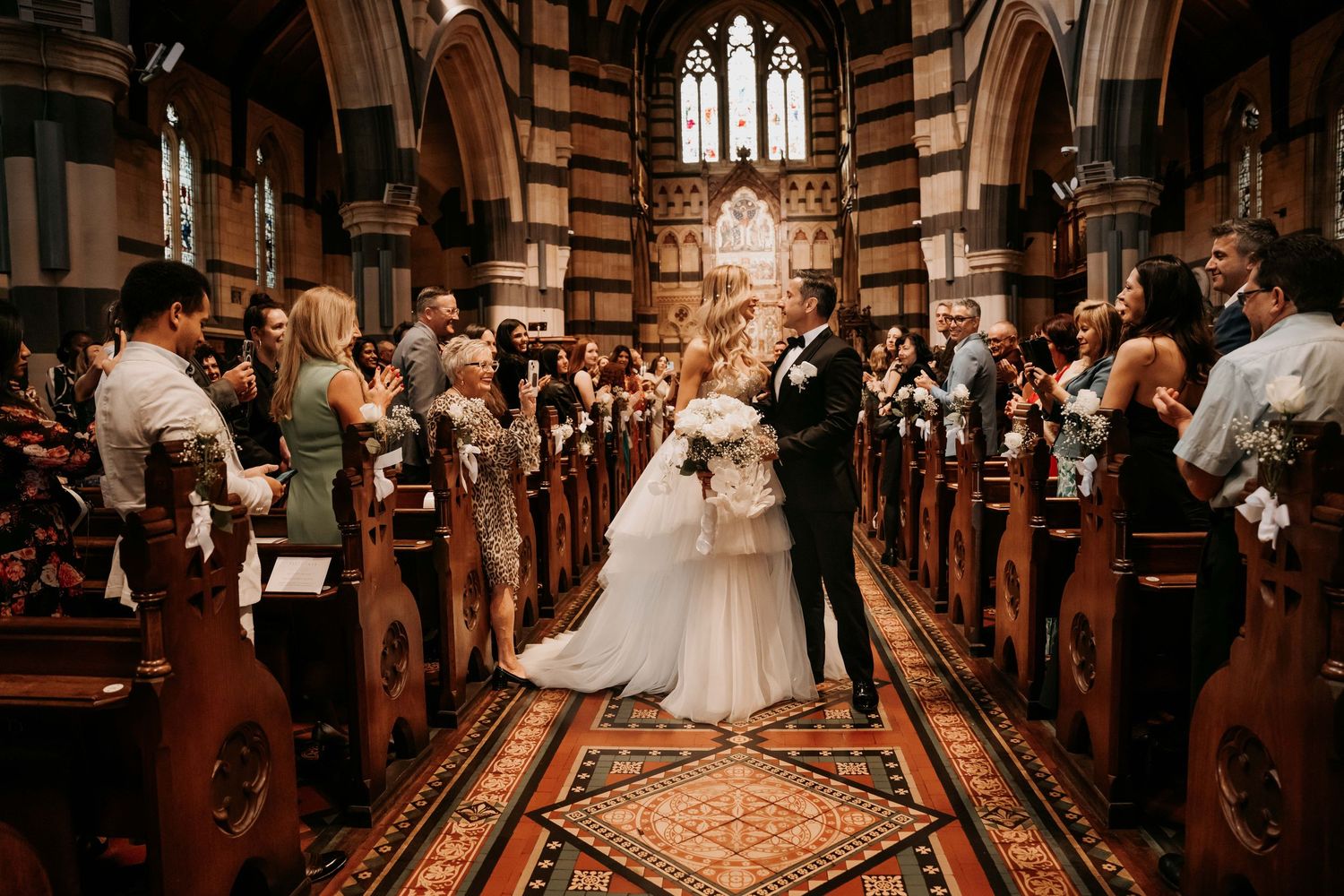 A series of wedding moments captured inside a historic church with stained glass windows and ornate architectural details.