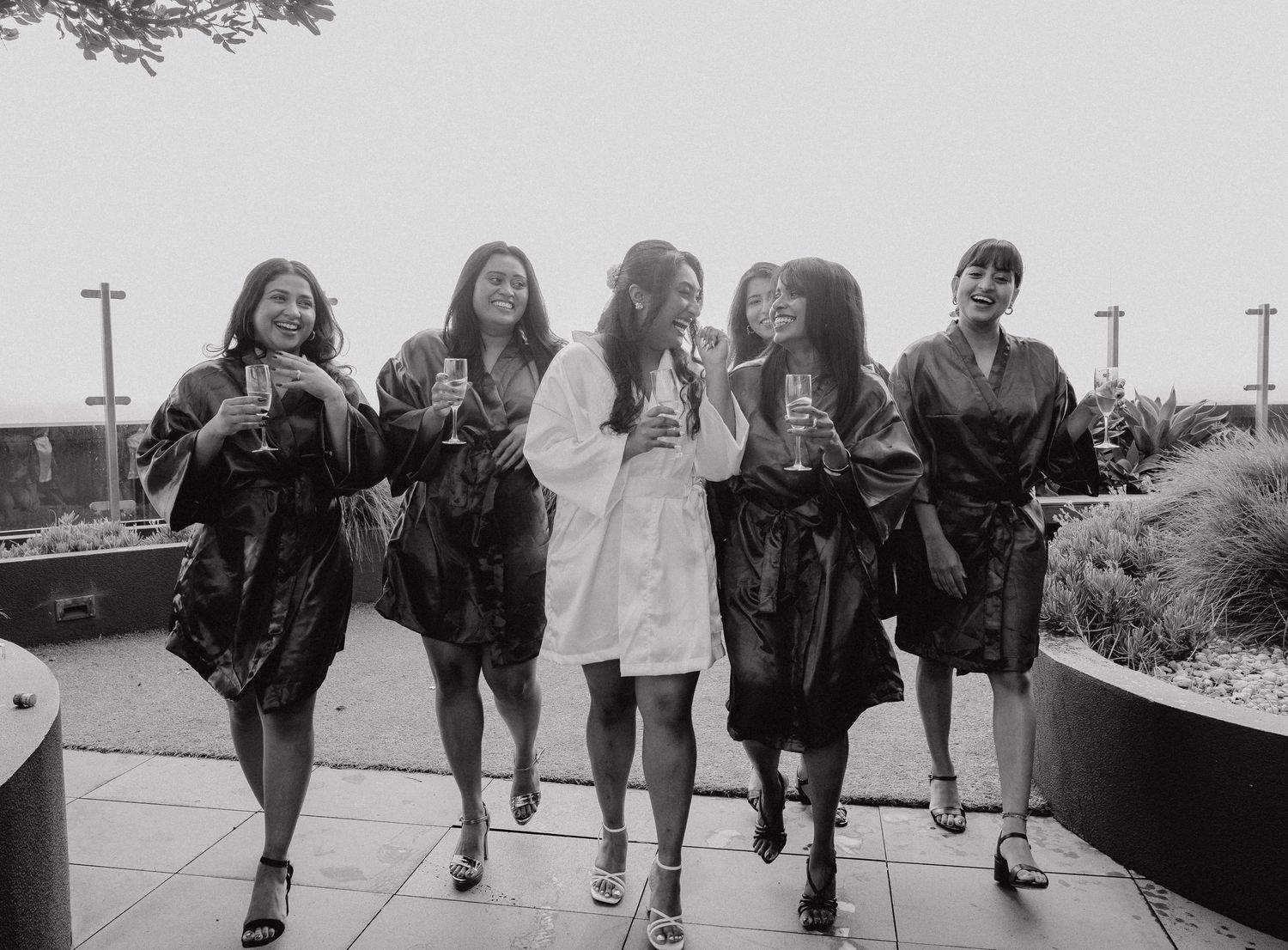 Black and white photo showing a row of people's legs walking in stylized shoes from different decades.