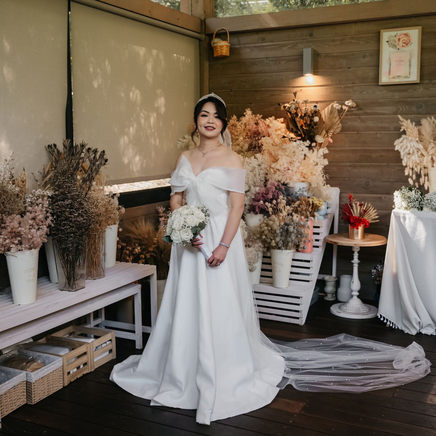 A modern rustic wedding venue interior with white floral arrangements and elegant decor on display tables.
