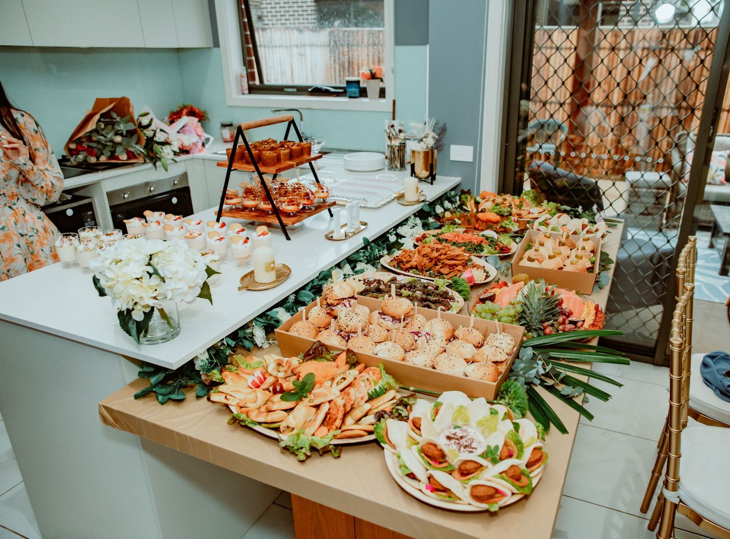 A long buffet table displays an elegant spread of seafood platters, appetizers and charcuterie boards at an event.