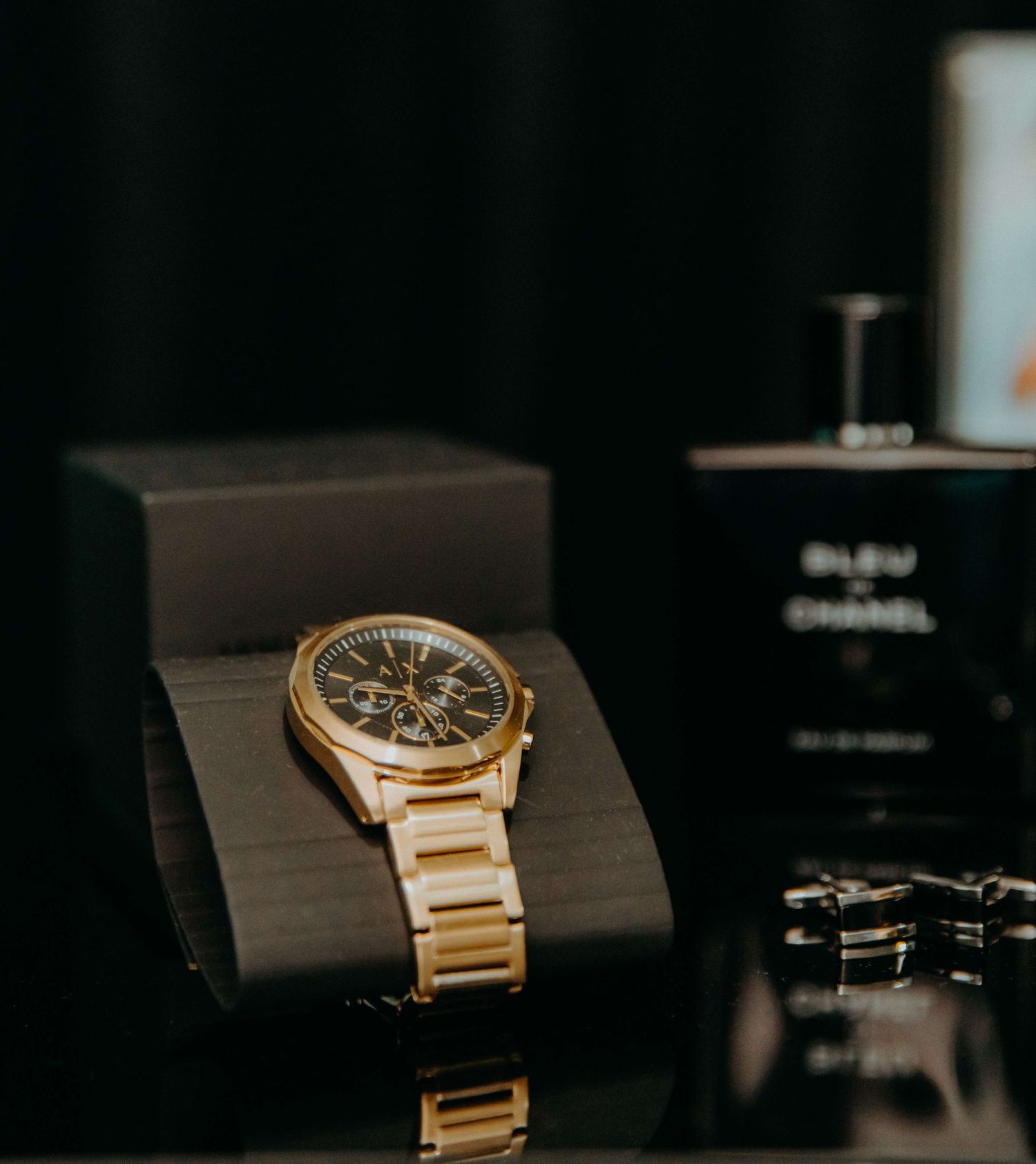 A gold luxury wristwatch displayed in sections against a dark background highlighting its elegant timepiece design.